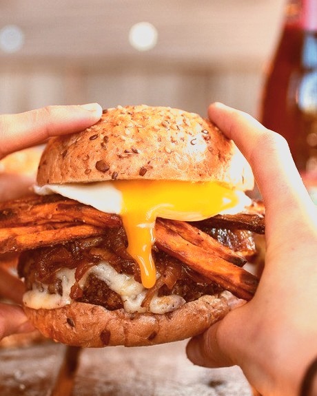 Epic Crispy Quinoa Burgers Topped with Sweet Potato Fries, Beer Caramelized Onions